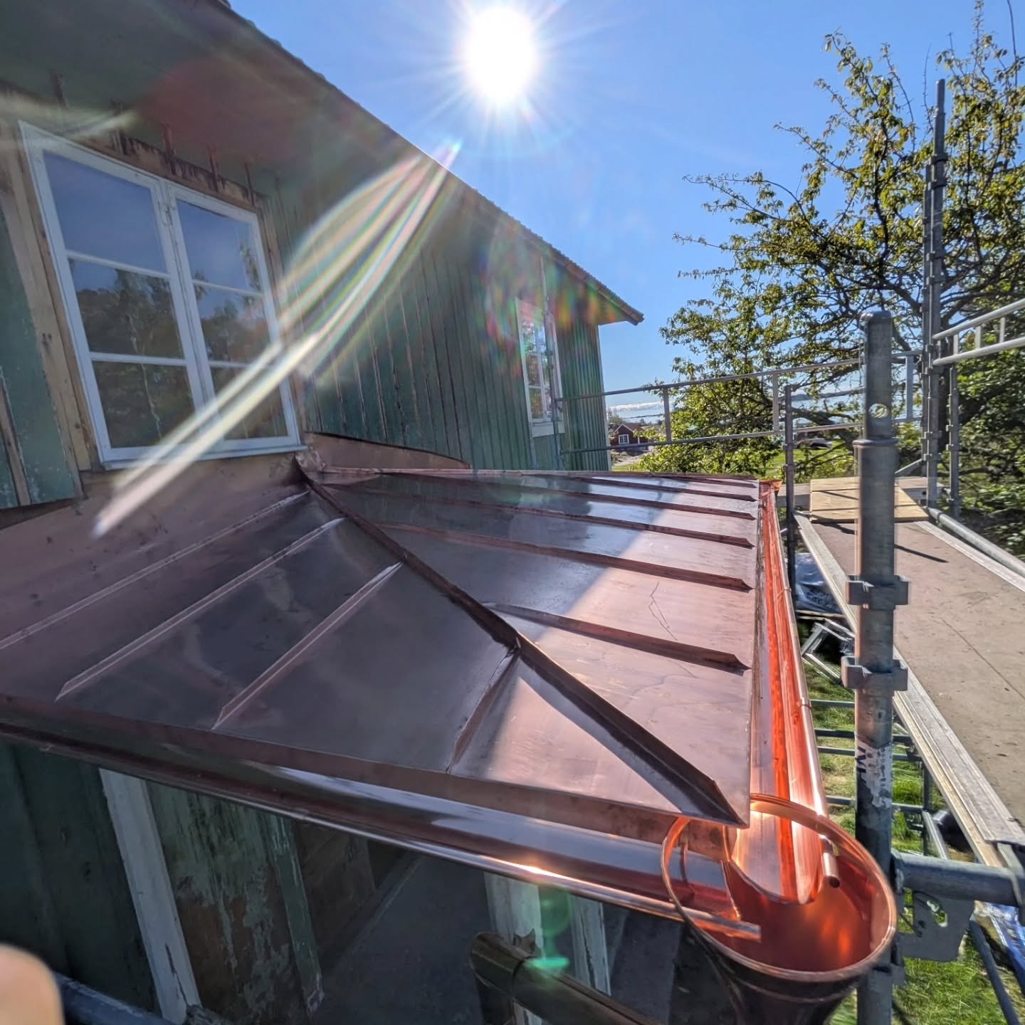 Nytt entrétak i koppar på ett grönt trähus på Örö i Misterhults skärgård